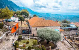 aventura albania, paisaje albanés con edificios históricos y paisajes de montaña, perfecto para turismo sostenible en albania, exploración cultural y viajes por la naturaleza en bjeshket e nemuna.