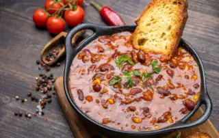 Estofado de berenjena y guindilla con perejil fresco y pan crujiente, cocina típica albanesa, perfecta para una auténtica aventura en Albania.
