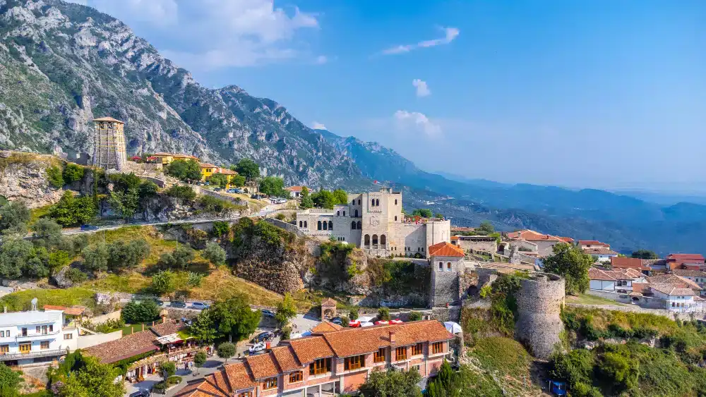 Kruja Albanien - Luftbild-Drohne-Blick-auf-die-Burg-Kruje-ihre-Festung-im-Kruje-Turm-Museum-mit-Bergen-im-Hintergrund-Albanien