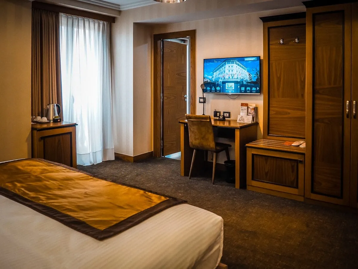 Gemütliches Hotelzimmer in Albanien mit Arbeitstisch, Flachbildfernseher und bequemen Betten für einen komfortablen Aufenthalt. Perfekt für Reisen und Erholung in Albanien.