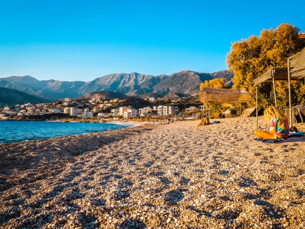 Potami Beach Himare met kiezelstrand en heuvels achter de stad