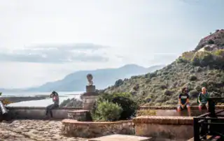 Vista de la montaña en Albania con los turistas, el mirador histórico con estatua y panorama natural, ideal para viajes de aventura y exploración de la naturaleza.