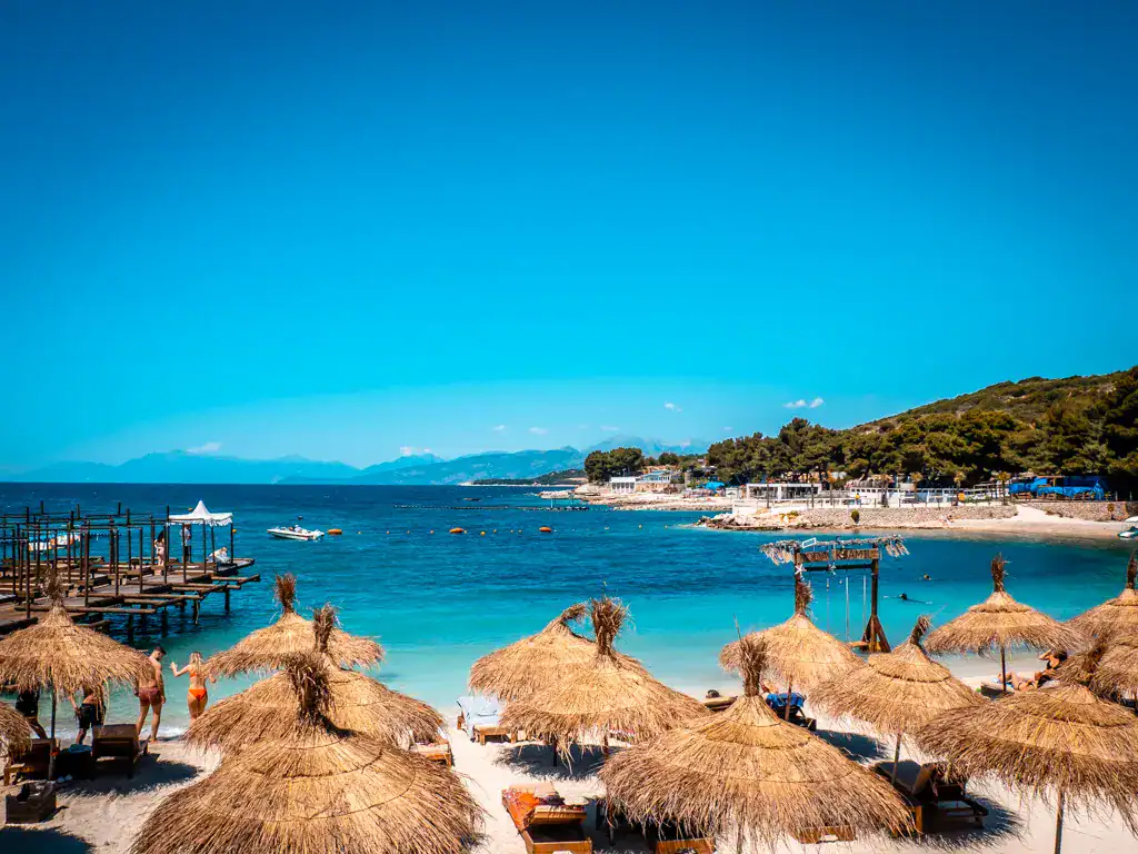 Lori Beach Ksamil Albanien mit blauem Wasser und Sonnenschirmen