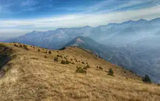 Hermoso paisaje montañoso albanés con amplias praderas y vistas panorámicas; destino ideal de vacaciones de aventura en Albania.