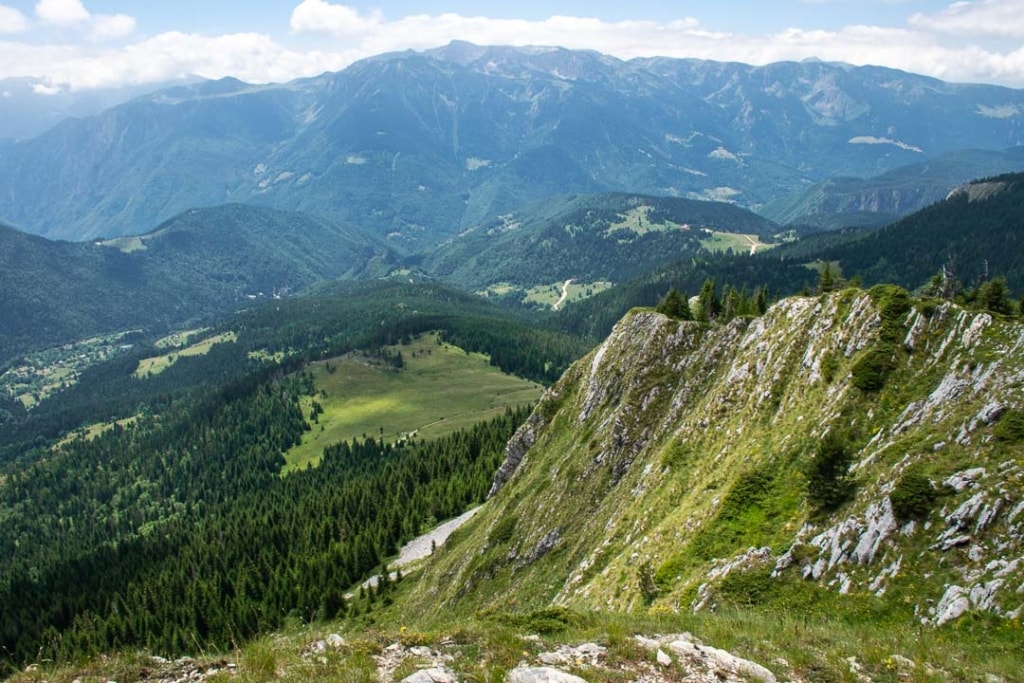 Krajobraz górski w Albanii z zielonymi lasami i stromymi klifami, idealny do uprawiania turystyki pieszej i eksploracji przyrody w Alpach Albańskich.