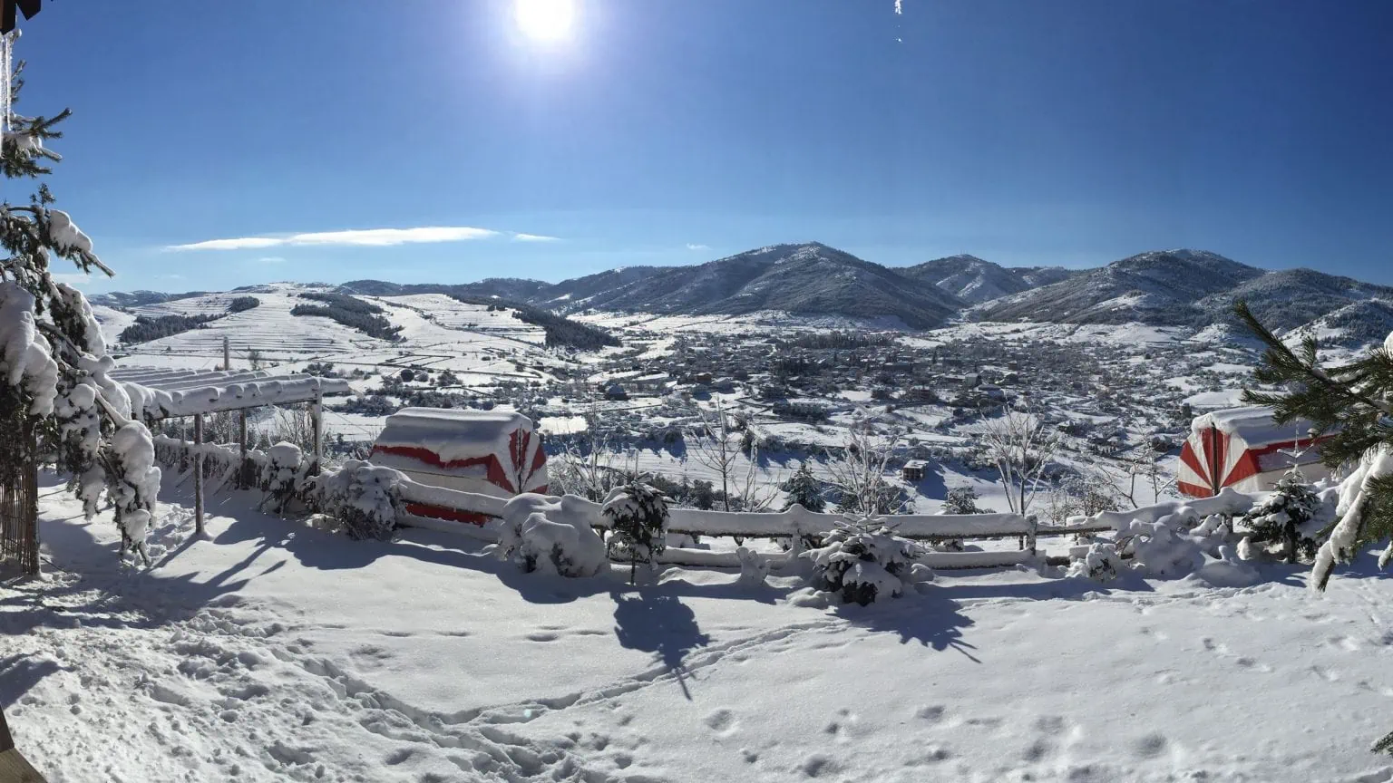 Weißer verschneiter Bergblick in Albanien, Winterlandschaft mit traditionellem Strandkorb und Zaun, klare blaue Himmel, ruhiges Winterparadies, Urlaub in Albanien im Schnee, Abenteuer Albanien.