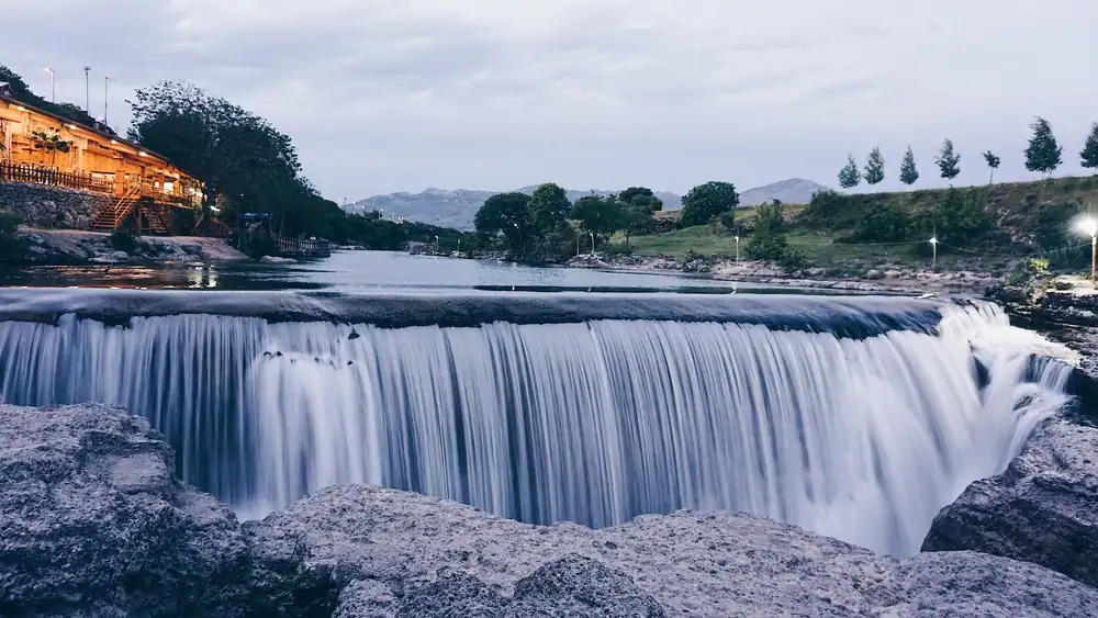 Beautiful Waterfall Niagara landscape, Podgorica, Montenegro. The light of restaurant in the left side near the mountain river. 