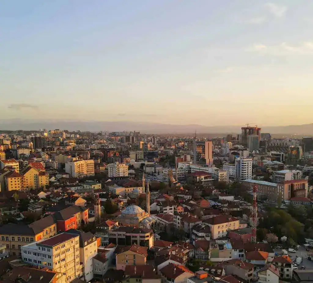 Die Top 10 Sehenswürdigkeiten in Pristina - Luftaufnahme der Stadt zum Sonnenuntergang