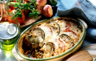 Cazuela de berenjenas frescas con tomates y queso, típica de la cocina albanesa, servida con aceite de oliva, tomates frescos, cebollas y hierbas aromáticas. La especialidad perfecta para una auténtica aventura en Albania.