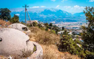 Aventura Albania: Paisaje pintoresco con montañas, casas tradicionales y naturaleza en Albania, ideal para actividades al aire libre y viajes culturales. Perfecto para los amantes de la aventura y la naturaleza.
