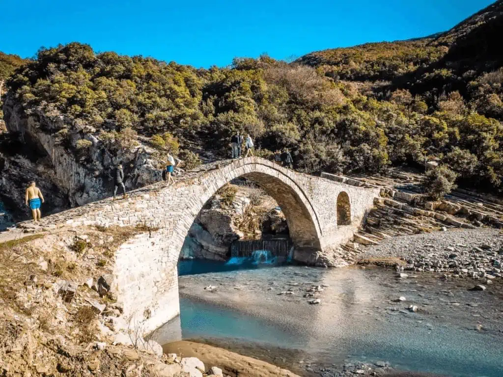 Oude stenen brug in de Albanese bergen met rivier en omringende natuur, ideaal voor wandelaars en natuurliefhebbers in Albanië.