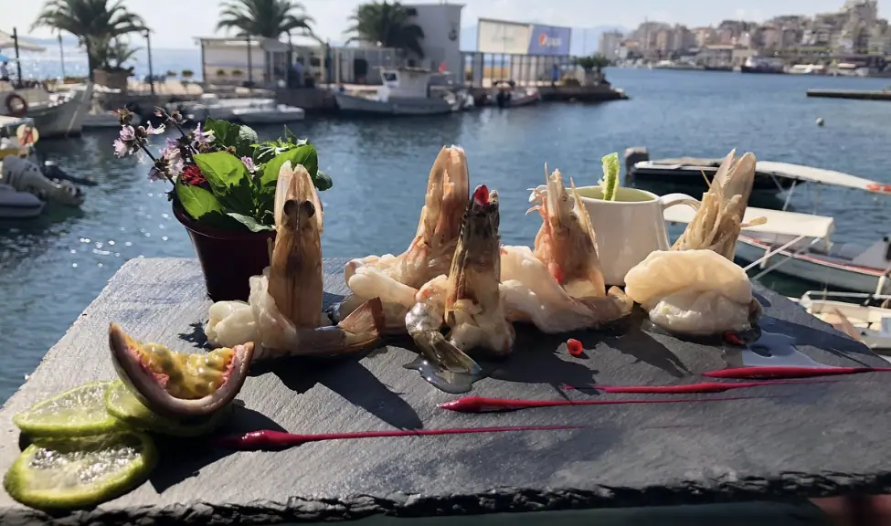 Zeevruchten (garnalen) in restaurant Limani Saranda met uitzicht op zee op de achtergrond