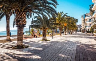 Colorido paseo marítimo en Saranda Albania con palmeras, edificios modernos y vistas al mar, ideal para vacaciones, relax y turismo en la costa albanesa.