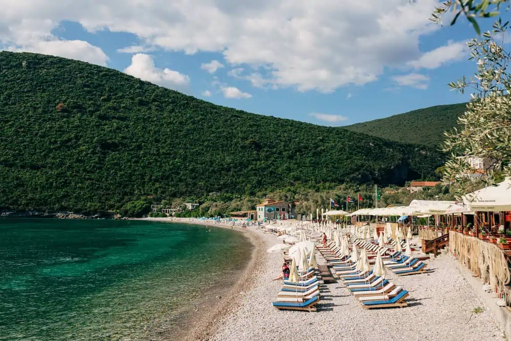 Montenegro strand Zanjice Strand Kiezelstrand met ligbedden voor glinsterend groen water aan zee
