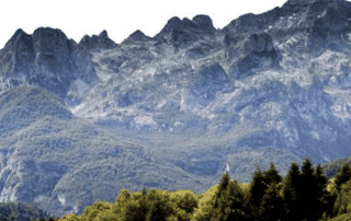 Berglandschap in Albanië met wandeltoeristen, indrukwekkende natuur en alpine bergtoppen, ideaal voor avontuurlijke vakanties in Albanië.
