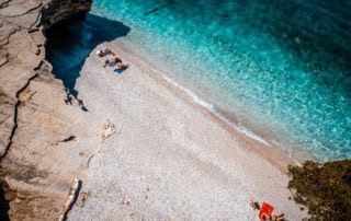 Relajante playa de Albania con aguas cristalinas y costa rocosa. Ideal para tomar el sol, nadar y disfrutar de la naturaleza. Un destino favorito para la aventura y la relajación.