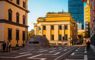 Edificios históricos de Tirana, Albania, con arquitectura moderna al fondo, al atardecer, destacados sobre hitos culturales y urbanos de Albania.