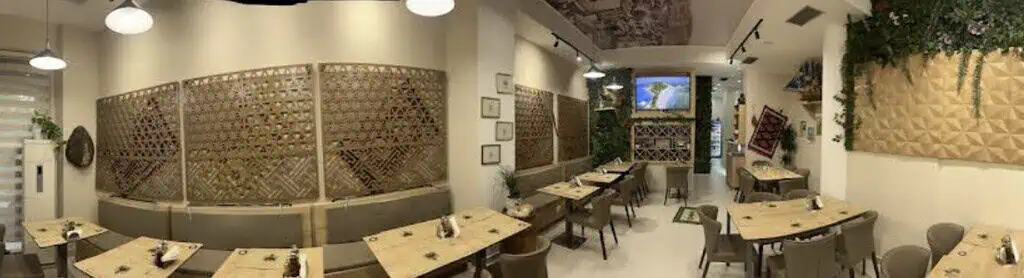 Gemütliches albanisches Restaurant mit modernem Dekor und Holzdesigns, ideal für authentische Reisen und kulinarische Abenteuer in Albanien.