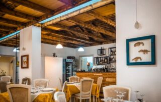 Luminoso y acogedor restaurante con techo de madera rústica y ambiente mediterráneo, ofrece cocina mediterránea y un ambiente acogedor en Albania.