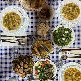 Delicioso desayuno albanés con sopas tradicionales y hierbas frescas, una auténtica experiencia albanesa.