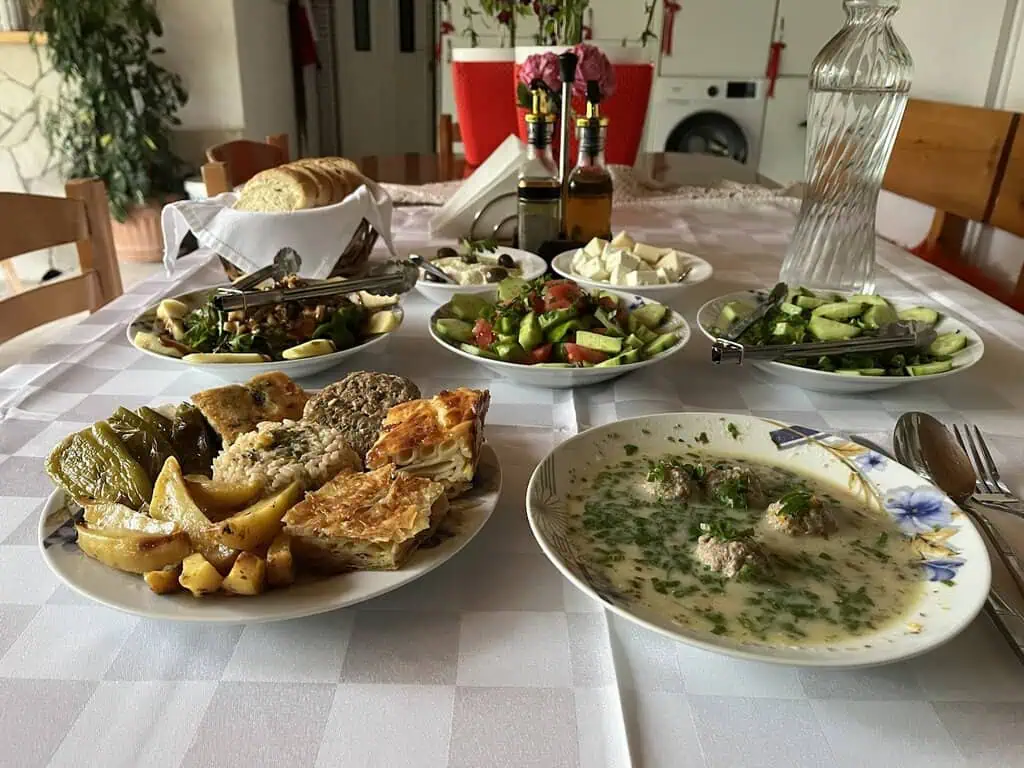 Traditioneel Albanees eten in het pension in Zuid-Albanië met verse salades, stoofpot, vers gebakken brood en yoghurt, perfect voor een authentieke Albanese avontuurlijke ervaring.
