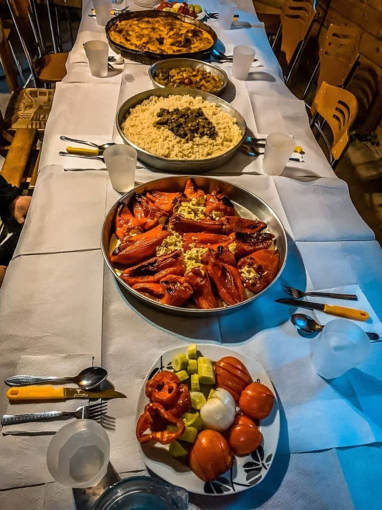 Deliciosas especialidades albanesas en una mesa festiva, como pimientos rellenos, arroces y guisos, ideales para vivir auténticas aventuras en Albania.