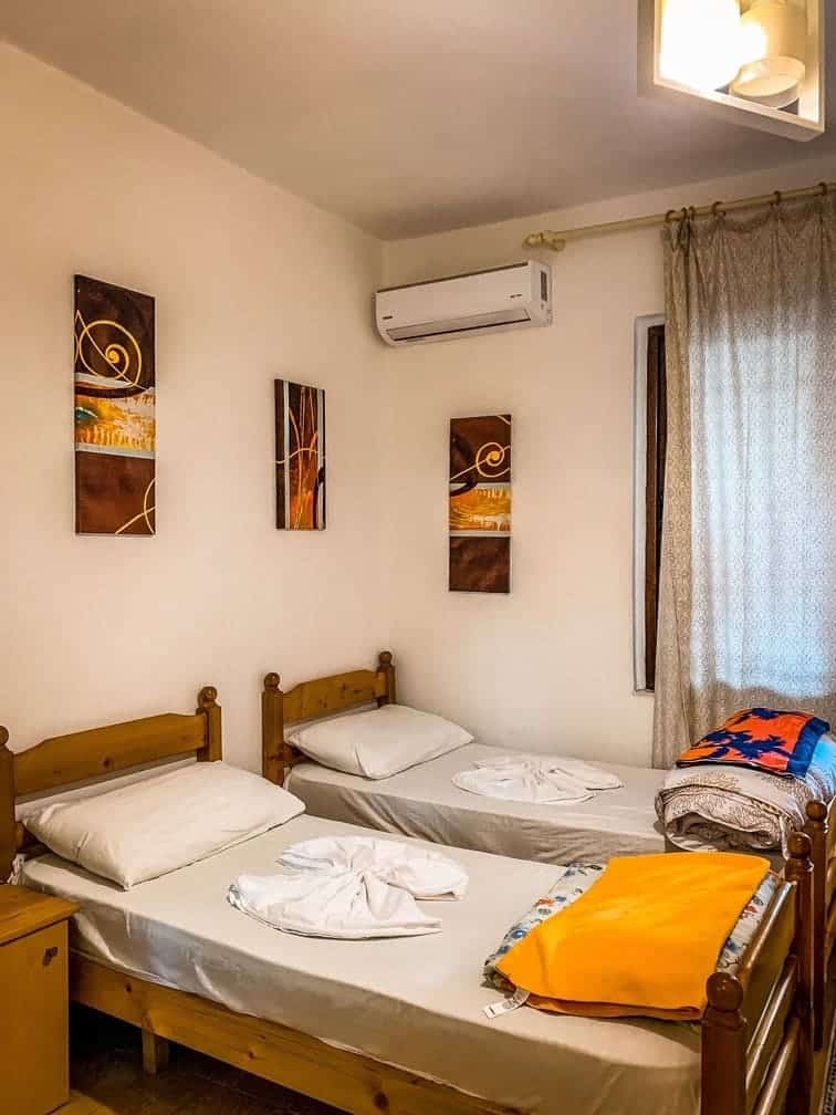 Acogedora habitación de hotel con camas dobles, decoración moderna y aire acondicionado, comodidad perfecta para sus vacaciones en Albania. Ideal para viajeros que quieran explorar la naturaleza y la cultura de Albania.