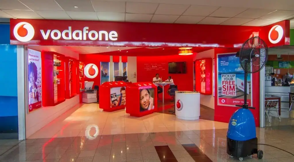 Vodafone-winkel in Tirana, de hoofdstad van Albanië, met opvallende branding, moderne faciliteiten en telecommunicatie-aanbiedingen, ideaal voor reizigers en inwoners die op zoek zijn naar mobiele diensten.